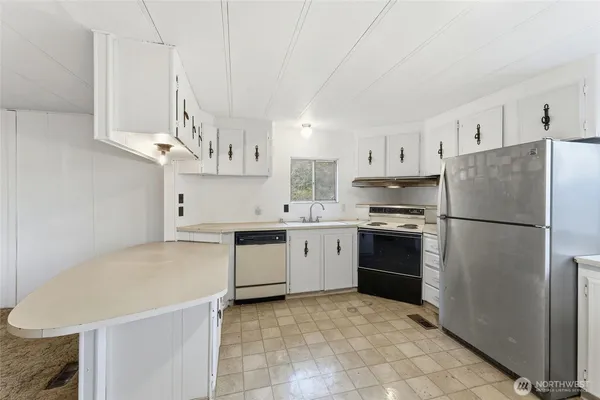 a kitchen with stainless steel appliances a refrigerator sink and cabinets
