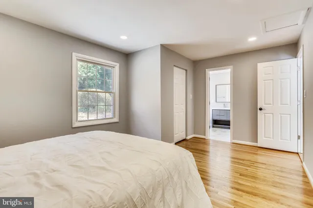 a spacious bedroom with a large bed and wooden floor