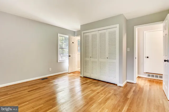 a view of an empty room with wooden floor
