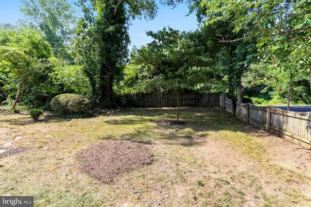 a view of a yard with wooden fence