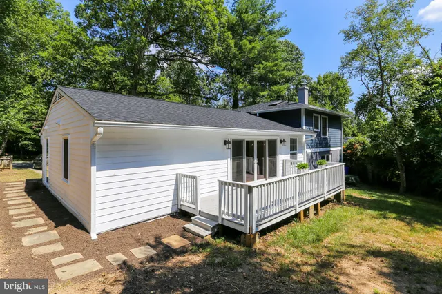 a view of a house with wooden deck front of house