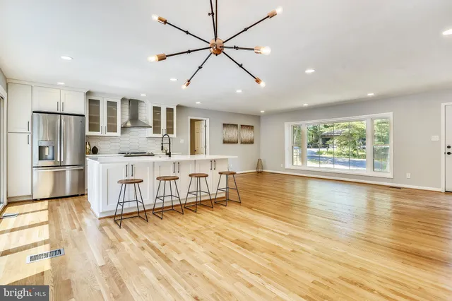 a large kitchen with stainless steel appliances granite countertop a refrigerator and a stove top oven