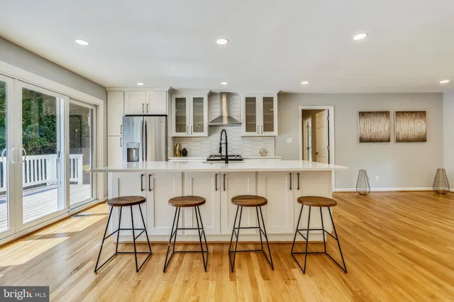 a dining hall with stainless steel appliances granite countertop a dining table chairs and view living room