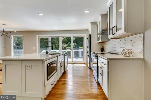 a large kitchen with stainless steel appliances granite countertop a stove and a sink
