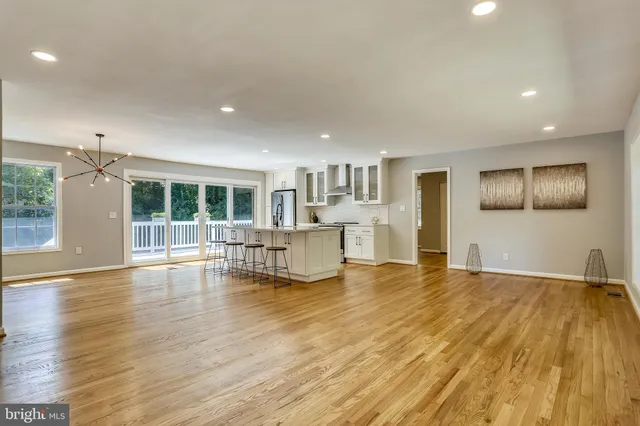 a view of empty room with wooden floor and windows