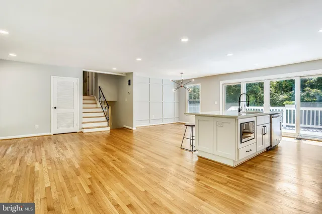 a large white kitchen with wooden floors and white walls