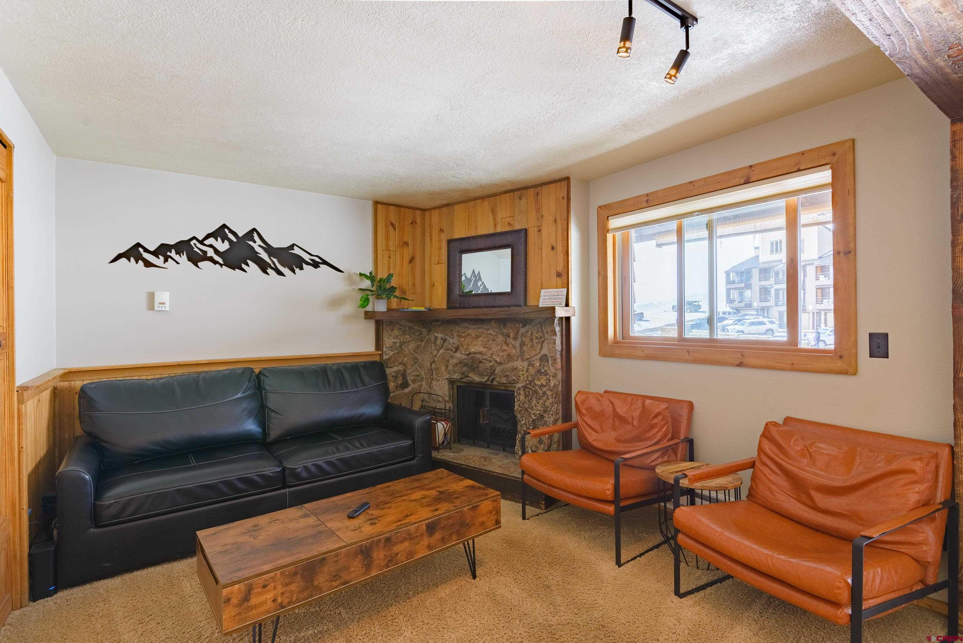 701 Gothic Road, Unit 306 Crested Butte, CO 81225 - Photo 2 of 25 a living room with furniture and a fireplace