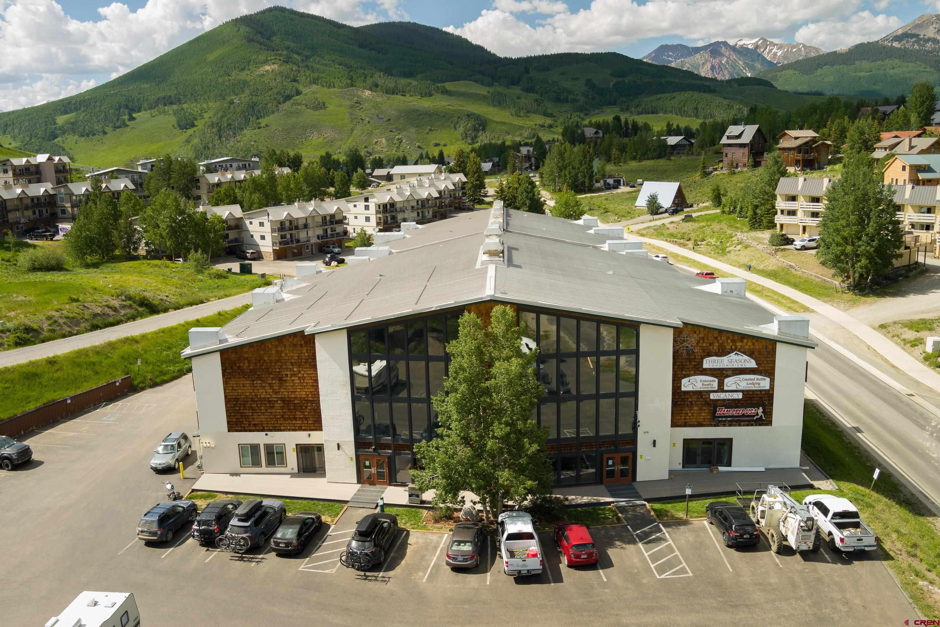 701 Gothic Road, Unit 306 Crested Butte, CO 81225 - Photo 21 of 25 a view of a patio with table and chairs potted plants with floor to ceiling window