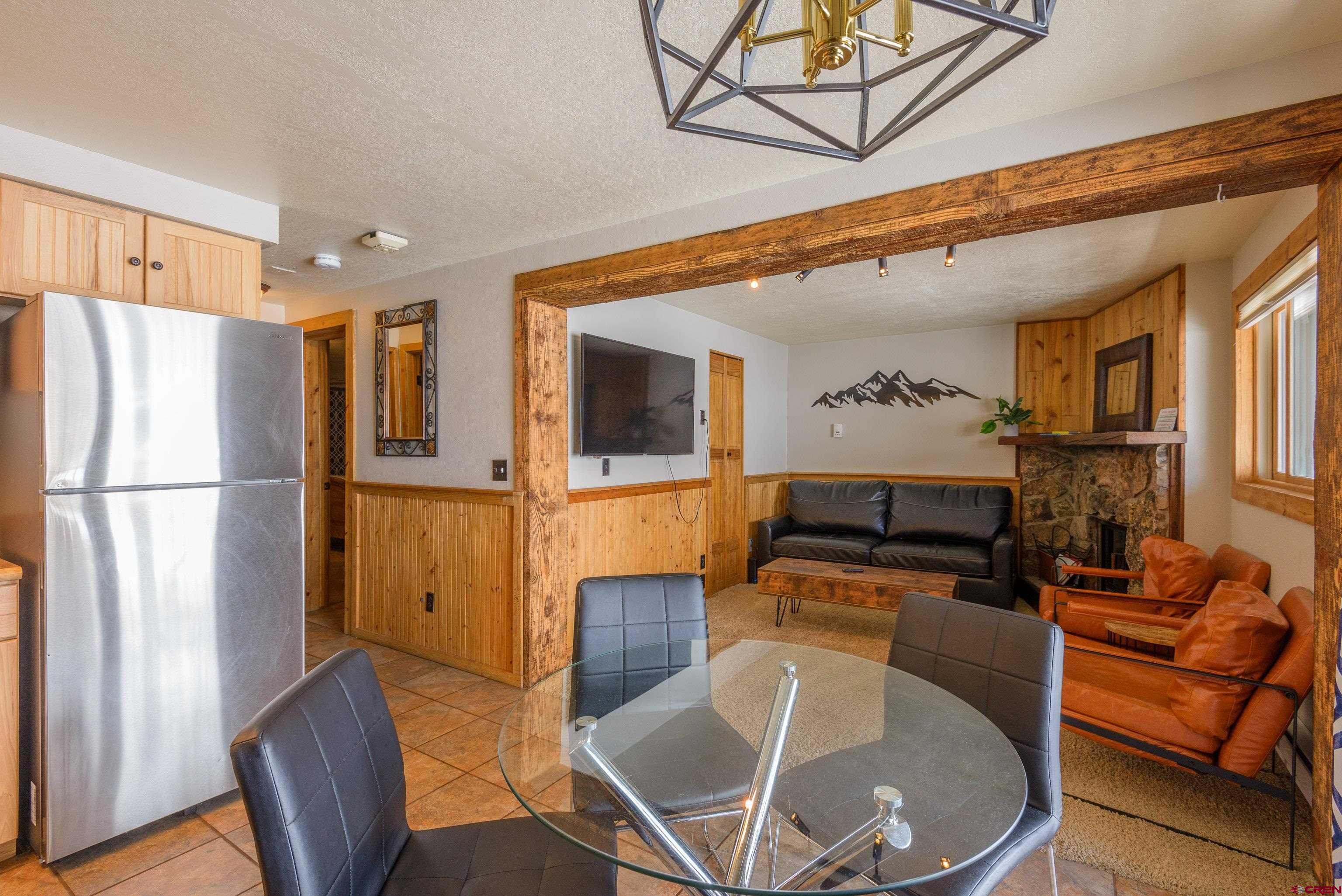 701 Gothic Road, Unit 306 Crested Butte, CO 81225 - Photo 5 of 25 a living room with furniture a flat screen tv and kitchen view