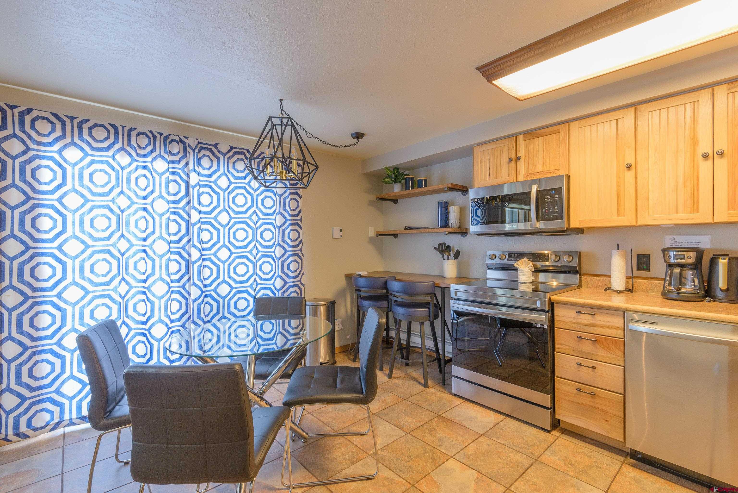 701 Gothic Road, Unit 306 Crested Butte, CO 81225 - Photo 7 of 25 a kitchen with stainless steel appliances granite countertop a stove a sink and a microwave
