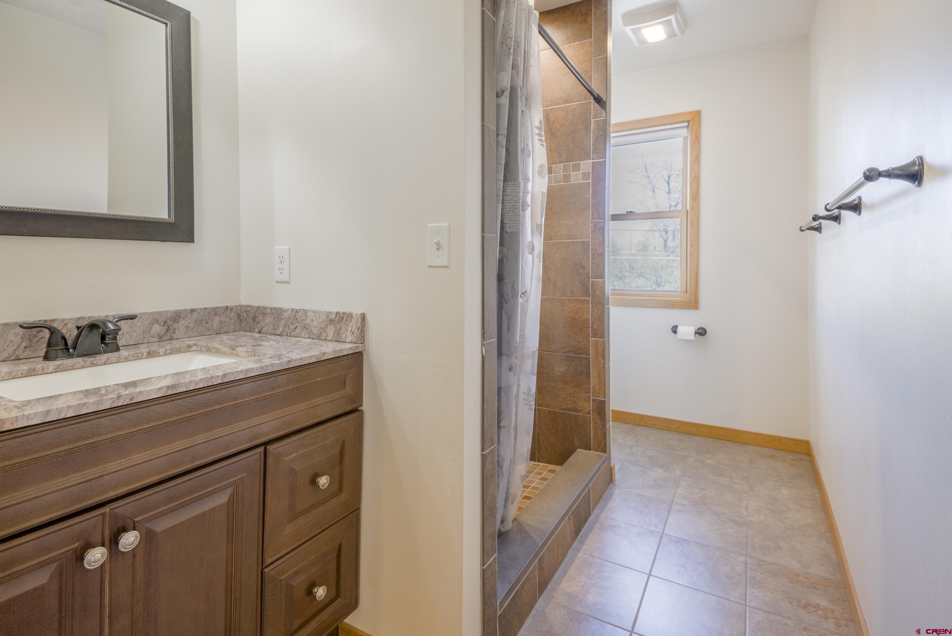 322 North Main Street Gunnison, CO 81230 - Photo 36 of 44 a bathroom with a granite countertop sink a mirror and a bathtub
