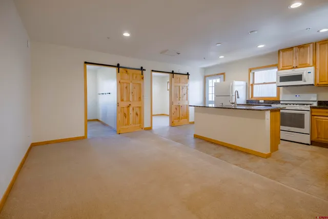 a large kitchen with stainless steel appliances granite countertop a refrigerator and a stove top oven