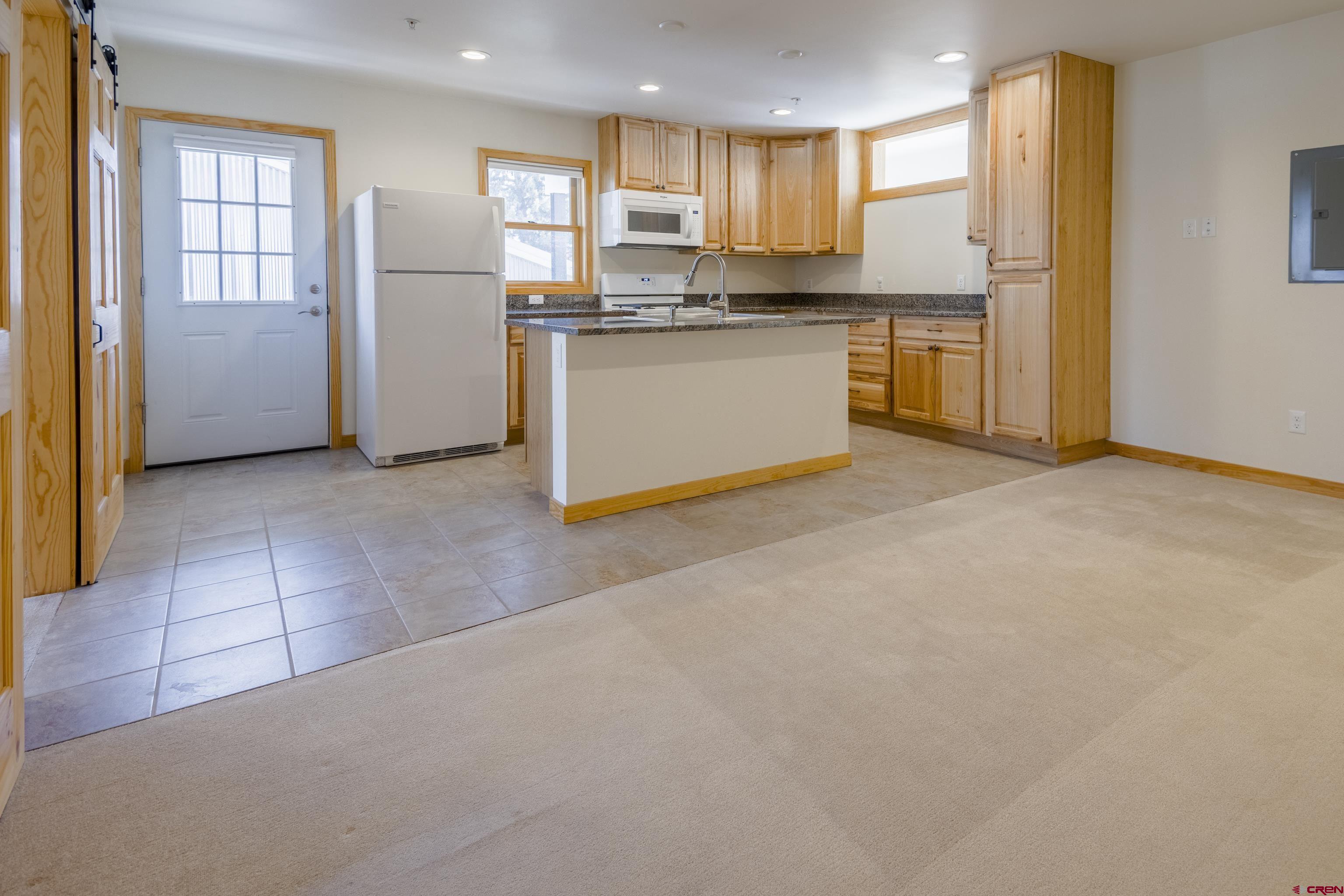 322 North Main Street Gunnison, CO 81230 - Photo 41 of 44 a view of kitchen with stainless steel appliances granite countertop a refrigerator a sink dishwasher with a dining table and chairs