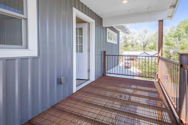 a view of a hallway with wooden floor and stairs
