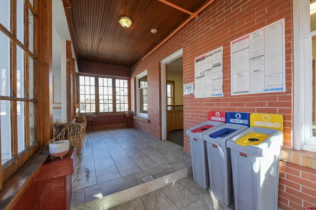 a view of a hallway with wooden floor and furniture