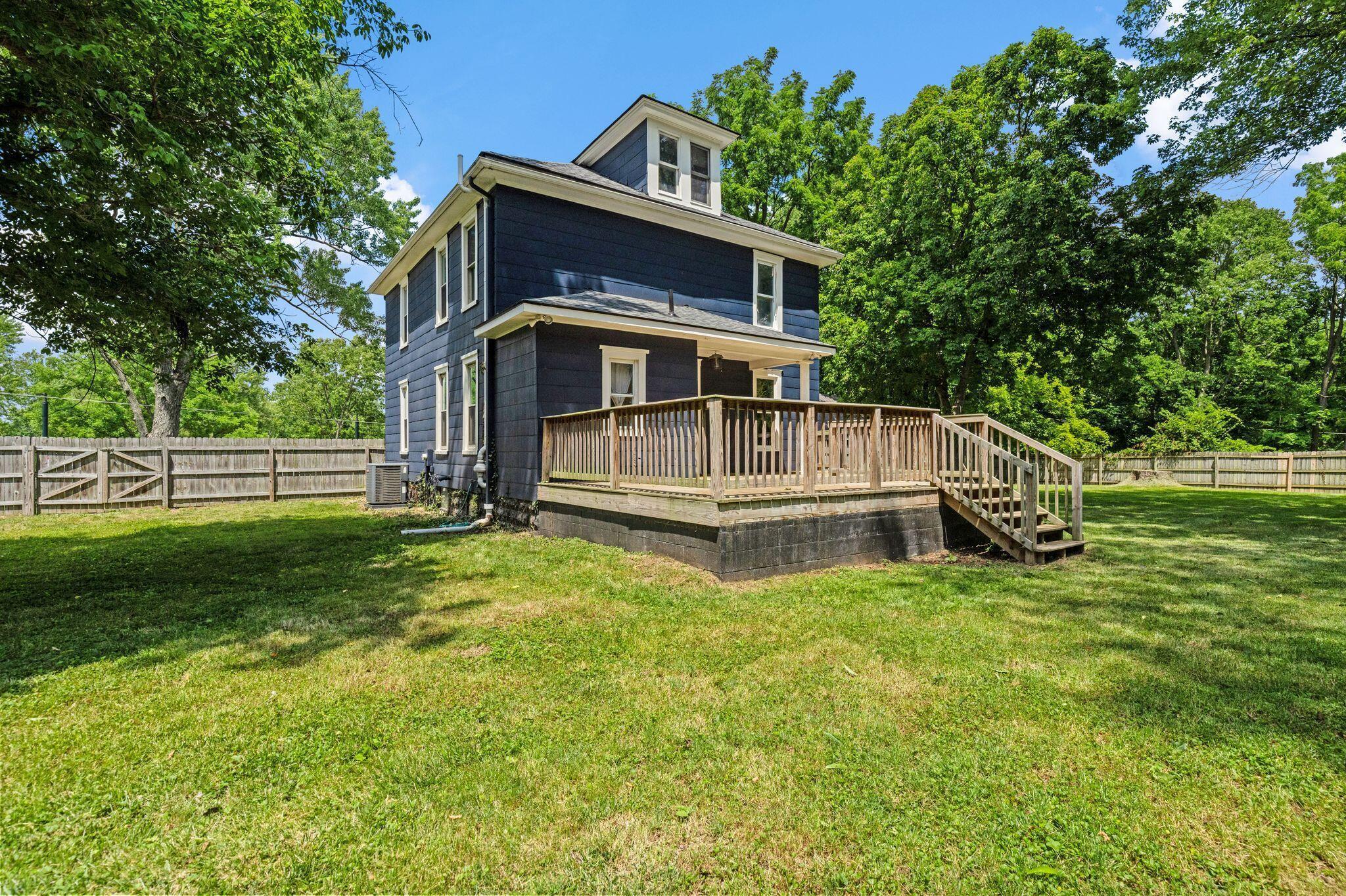 107 Price Road Columbus, OH 43230 - Photo 37 of 51 Rear exterior featuring a dark blue facade, multiple windows, a wood deck with stairs, a dormer window, and a surrounding wood fence