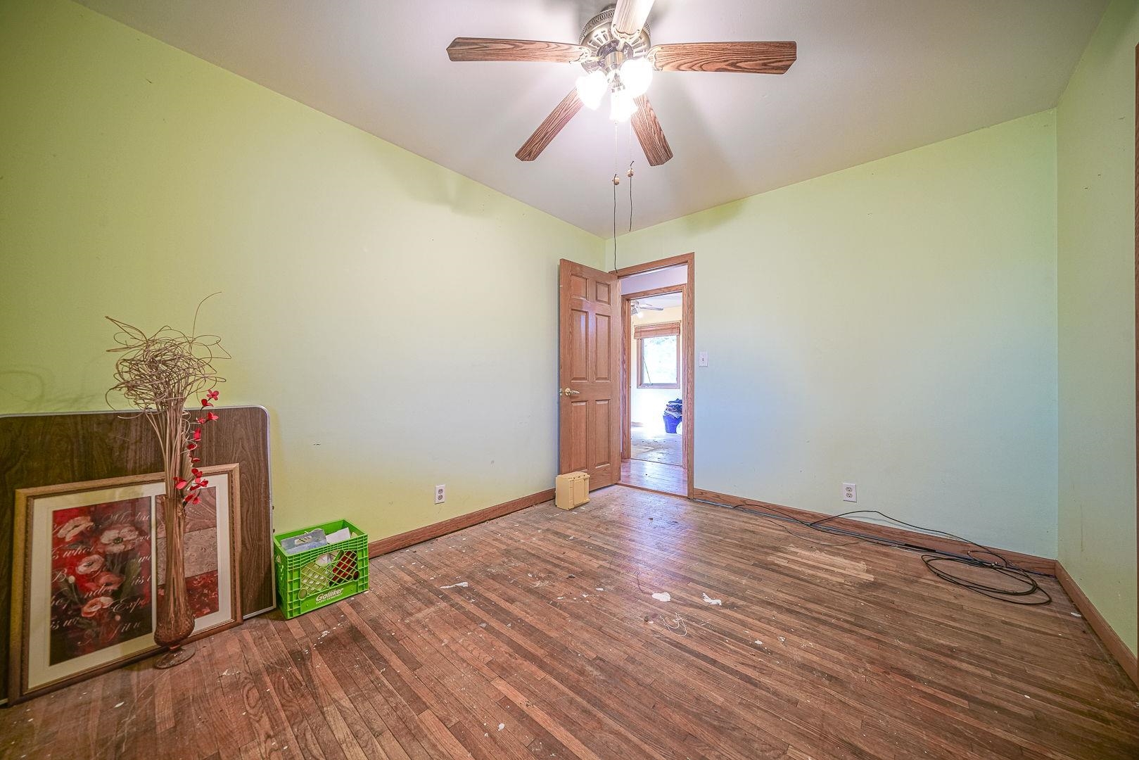 8330 North Kishwaukee Road Stillman Valley, IL 61084 - Photo 14 of 37 a view of an empty room with a window and wooden floor