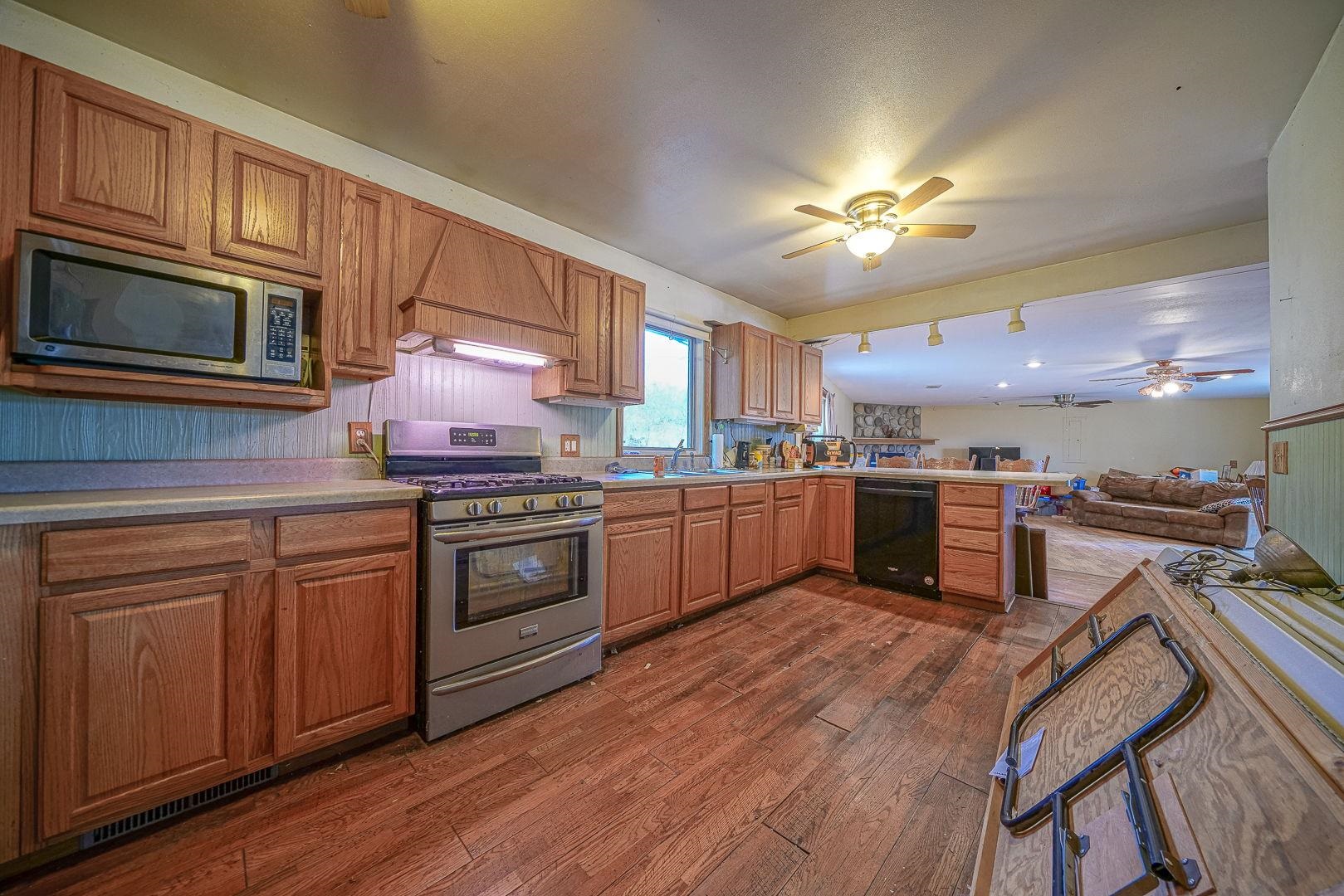 8330 North Kishwaukee Road Stillman Valley, IL 61084 - Photo 3 of 37 a kitchen with stainless steel appliances granite countertop a stove cabinets and wooden floor