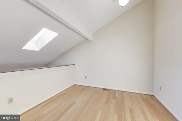 a view of a room with wooden floor and white walls