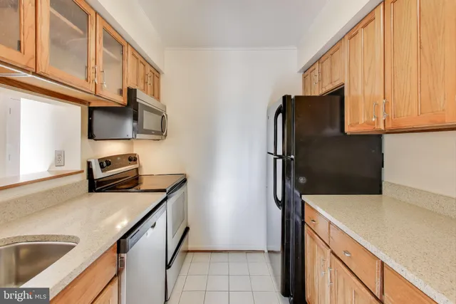 a kitchen with granite countertop a refrigerator and a sink