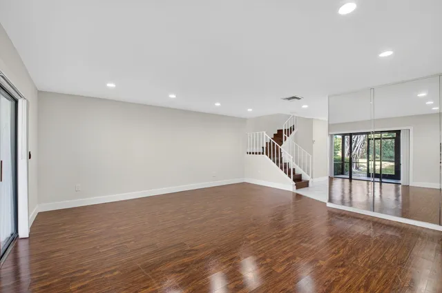 a view of a livingroom with wooden floor and stairs