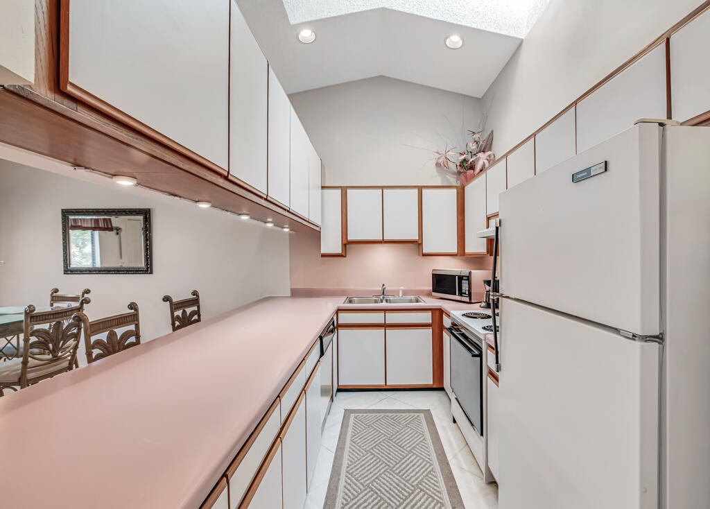 815 Andrew Redding Road, Unit 202 Lantana, FL 33462 - Photo 11 of 30 a kitchen with stainless steel appliances granite countertop a refrigerator a stove and a sink with cabinets