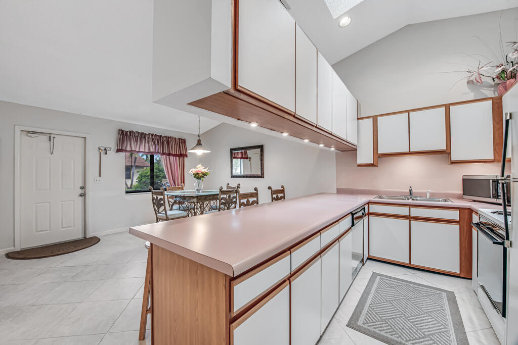 815 Andrew Redding Road, Unit 202 Lantana, FL 33462 - Photo 12 of 30 a kitchen with stainless steel appliances granite countertop a sink and cabinets