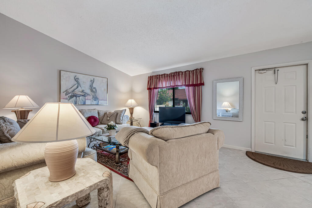815 Andrew Redding Road, Unit 202 Lantana, FL 33462 - Photo 6 of 30 a living room with furniture a window and a flat screen tv