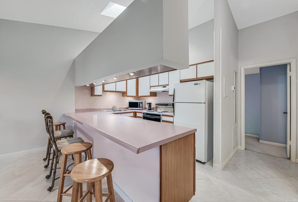 815 Andrew Redding Road, Unit 202 Lantana, FL 33462 - Photo 9 of 30 a kitchen with a refrigerator a table and chairs