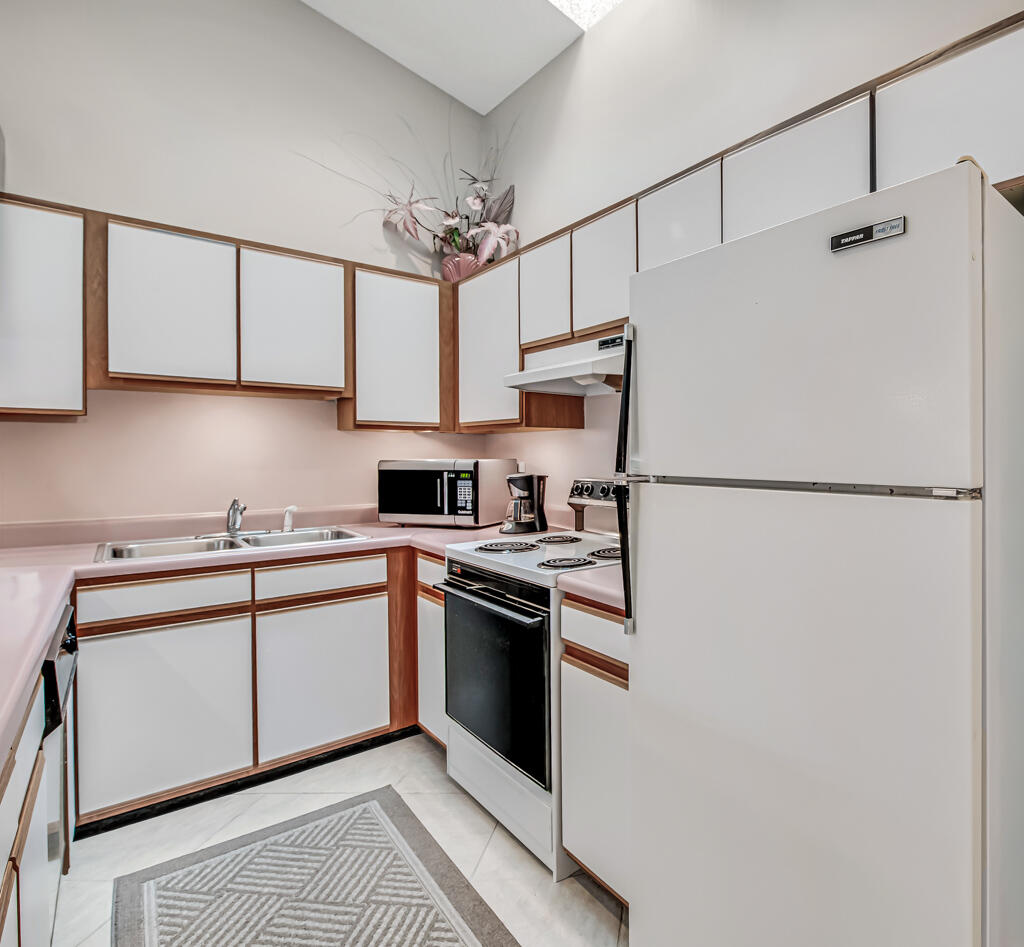 815 Andrew Redding Road, Unit 202 Lantana, FL 33462 - Photo 10 of 30 a kitchen with stainless steel appliances a sink and a refrigerator