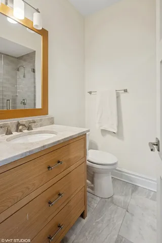 a bathroom with a granite countertop toilet and a sink