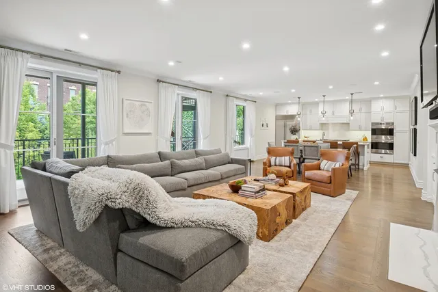 a living room with furniture kitchen and a large window