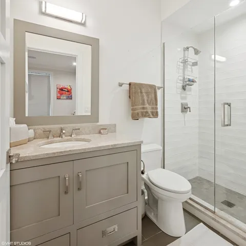 a bathroom with a toilet sink vanity and shower