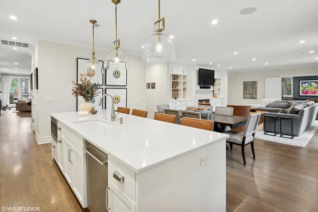 a large white kitchen with lots of counter space and stainless steel appliances