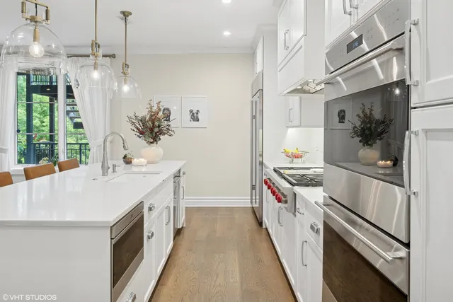 a kitchen with stainless steel appliances a stove a sink and a refrigerator