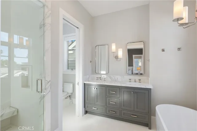a bathroom with a granite countertop sink a toilet and a mirror