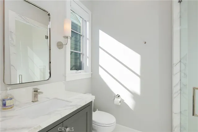 a bathroom with a sink toilet a mirror and shower
