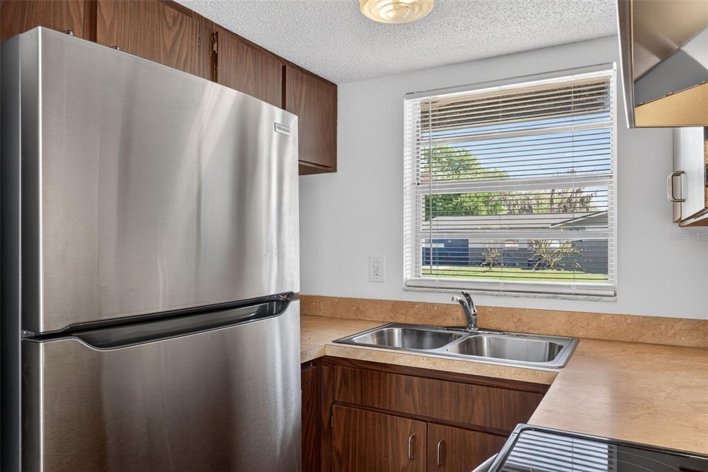 4915 Billy Direct Lane Lutz, FL 33559 - Photo 18 of 73 a kitchen with stainless steel appliances a refrigerator and a sink
