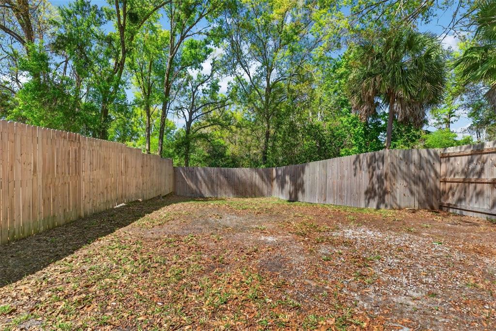 4915 Billy Direct Lane Lutz, FL 33559 - Photo 51 of 73 a backyard of a house with large trees and wooden fence