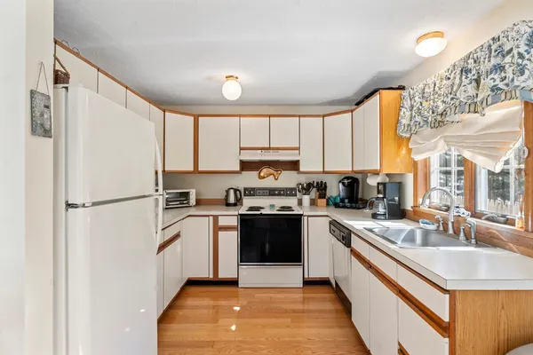 a kitchen with a sink a refrigerator a window and cabinets