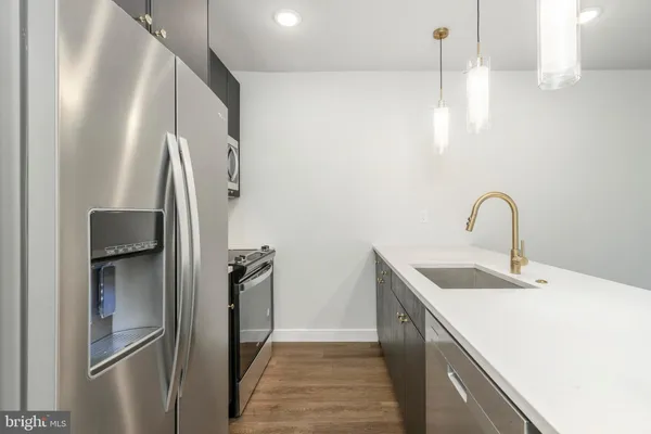 a kitchen with stainless steel appliances granite countertop a refrigerator and a sink