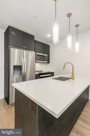a kitchen with kitchen island a counter top space cabinets and stainless steel appliances