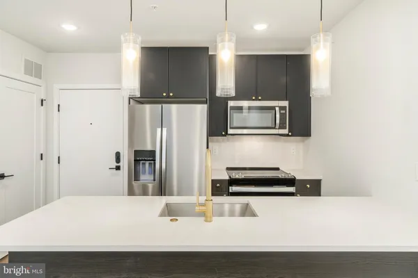 a kitchen with stainless steel appliances a refrigerator and a stove top oven