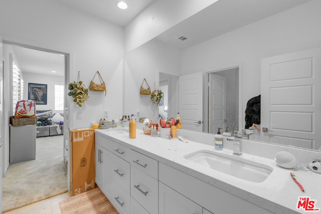 24477 Oneida Street Moreno Valley, CA 92553 - Photo 30 of 51 a bathroom with a double vanity sink and a mirror