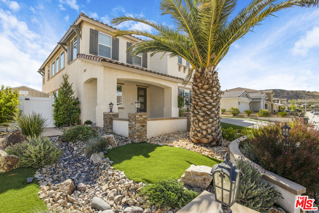 24477 Oneida Street Moreno Valley, CA 92553 - Photo 6 of 51 a view of a white house next to a yard with plants and trees