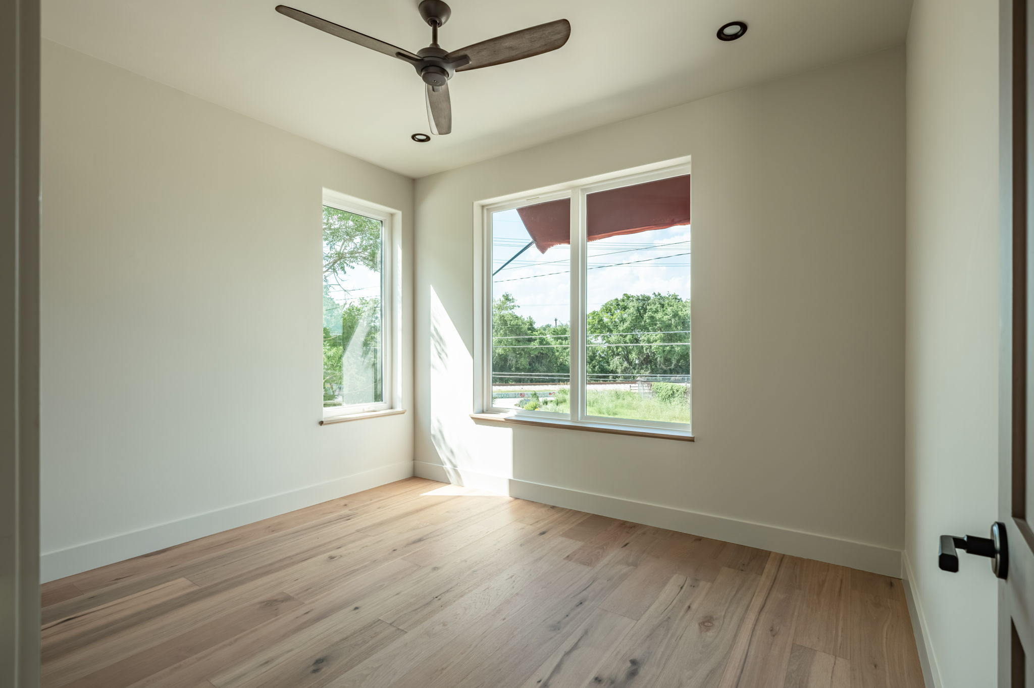 4713 Bolm Road Austin, TX 78702 - Photo 33 of 40 Hardwood flooring throughout featuring two large windows, a ceiling fan, and recessed lighting