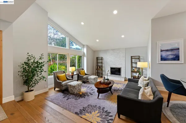 a large kitchen with stainless steel appliances a large counter top a stove a chimney a sink and a refrigerator