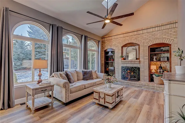 a living room with fireplace furniture and a large window