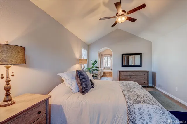 a bedroom with a large bed and a chandelier