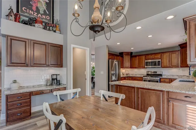 a kitchen with stainless steel appliances granite countertop wooden cabinets a stove top oven a sink and dishwasher